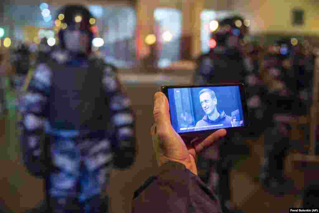 Москва. Журналіст дивиться пряму трансляцію судового засідання у справі Навального, а навпроти нього &ndash; силовики перед будівлею Симонівського суду