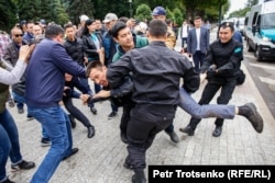 Полиция алаңға келгендердің бірін автобусқа әкетіп барады. Алматы, 9 маусым 2019 жыл.